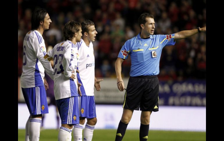 Los centrocampistas Pablo Barrera(i), Leonardo Ponzio (2i) y Luis García (2d) reclaman una falta durante el partido contra Osasuna. EFE  /