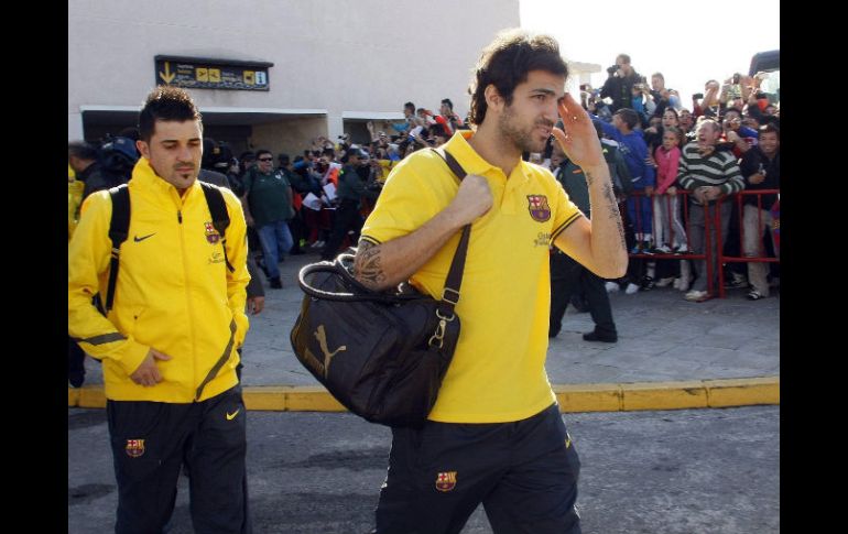 David Villa (I) y Cesc Fábregas fueron recibidos ayer por los aficionados tras llegar al aeropuerto de Granada. EFE  /