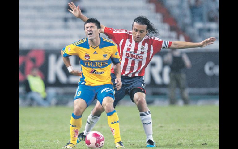 Héctor Reynoso, zaguero de Chivas, llega por atrás y le da un ligero golpe a su tocayo Mancilla, de Tigres. MEXSPORT  /