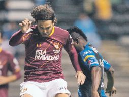 Duilio Davino (izq.) pelea por el balón con el jugador del Puebla, Duvier Riasco. MEXSPORT  /