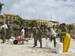 Trabajadores llenan costales con arena preparándose para la llegada de ''Rina''. AFP  /