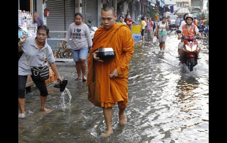 Un monje budista atraviesa una calle inundada situada junto al río Chao Phraya, en Bangkok (Tailandia). EFE  /