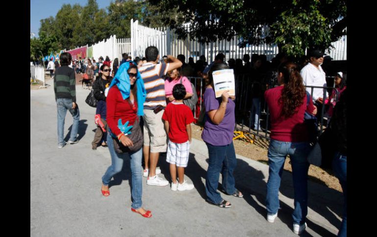 Largas filas se forman hoy en busca de un boleto para entrar al Centro Acuático, uno de los sitios donde se han detectado revendedores.  /