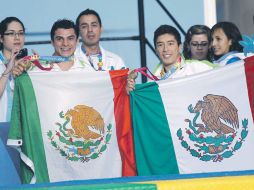 Yahel Castillo y Julián Sánchez muestran sus medallas que ganaron en el trampolín de tres metros. NTX  /