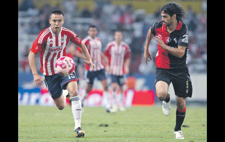 Érick ''Cubo'' Torres, autor del tanto de Chivas, conduce el balón, seguido de cerca por el rojinegro Jonathan Lacerda.  /