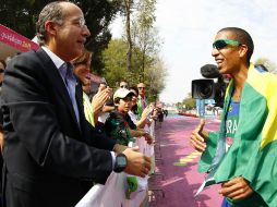 Esta mañana, el mandatario asistió a la prueba de maratón varonil. En la foto felicita al ganador Solonei Siva. REUTERS  /