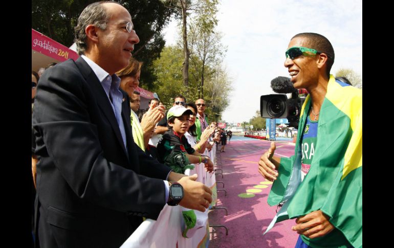 Esta mañana, el mandatario asistió a la prueba de maratón varonil. En la foto felicita al ganador Solonei Siva. REUTERS  /