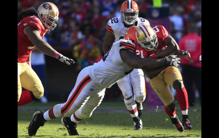 El corredor de los 49ers, Frank Gore (21) es tacleado por Ahtyba Rubin, de los Cafes durante el juego. AP  /