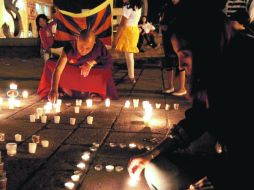 Budistas encienden velas en la Plaza Tapatía.  /