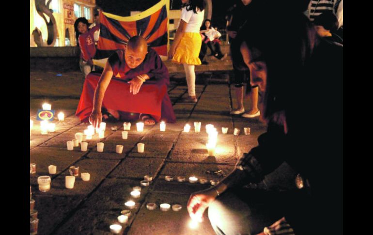 Budistas encienden velas en la Plaza Tapatía.  /