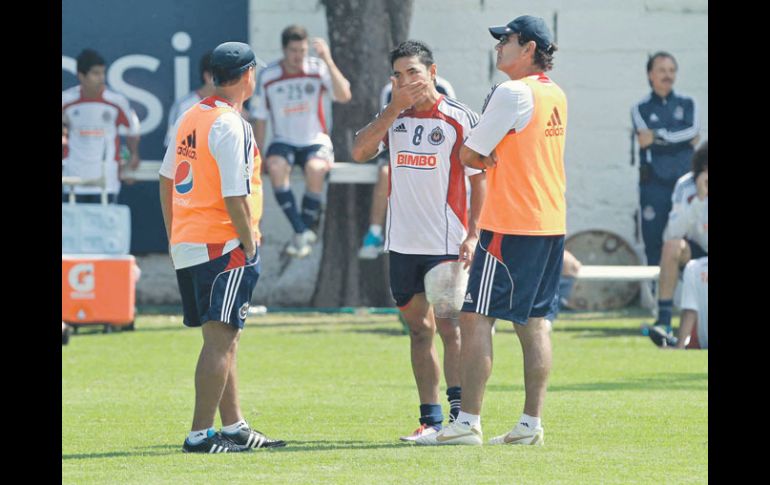 Marco Fabián (centro), con hielo en su pierna, dialoga con el auxiliar técnico, Sergio Lugo, y con el estratega Quirarte.  /