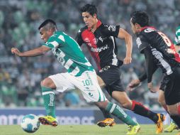 ''Hachita'' Ludueña es seguido por zaguros rojinegros, durante el partido. MEXSPORT  /