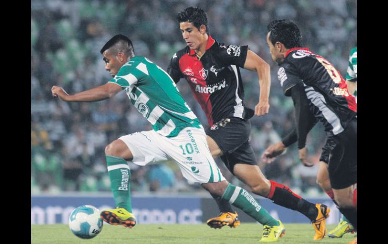 ''Hachita'' Ludueña es seguido por zaguros rojinegros, durante el partido. MEXSPORT  /