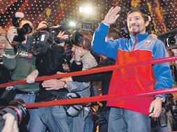 Decenas de representantes de los medios de comunicación se volcaron a la llegada de Manny Pacquiao (der.). AP  /