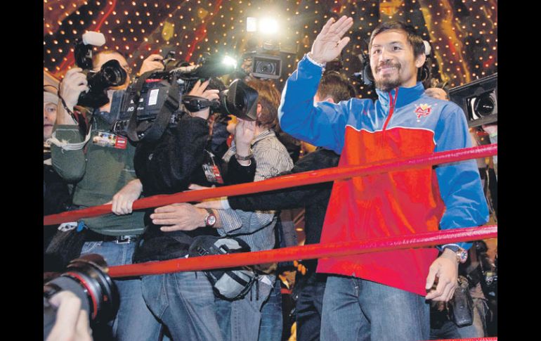 Decenas de representantes de los medios de comunicación se volcaron a la llegada de Manny Pacquiao (der.). AP  /