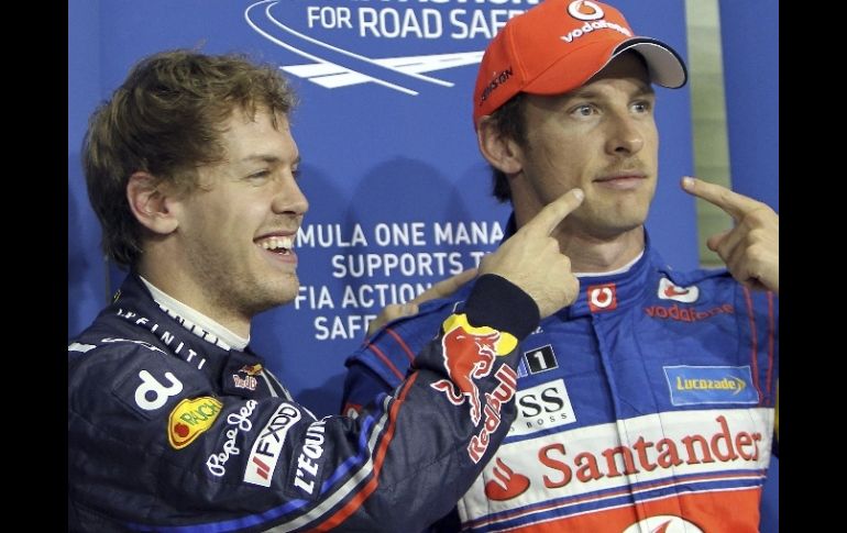 Sebastian Vettel (izda), celebra la primera posición conseguida junto al británico de McLaren Mercedes, Jenson Button, tercero. EFE  /