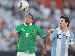 Lionel Messi (der.) ve como es despojado del balón por el mediocampista boliviano Jaime Robles. AP  /