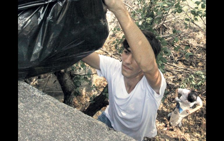 Uno de los voluntarios saca un costal que contiene desechos recolectados ayer en el Parque Mirador.  /