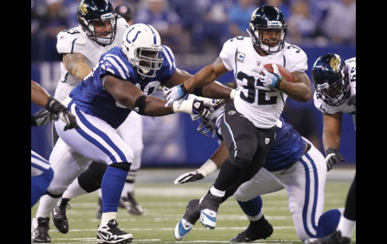 Maurice Jones-Drew, de los Jaguares de Jacksonville  corre fuera del alcance del tacleador de Potros Antonio Johnson. AP  /