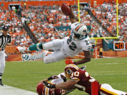 El correor Reggie Bush (22)salta antes de la zona de anotación sobre el defensa de Washington LaRon Landry (30). AP  /