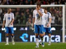 Los jugadores bosnios abandonan la cancha junto con sus esperanza de clasificar en esta repesca. AP  /