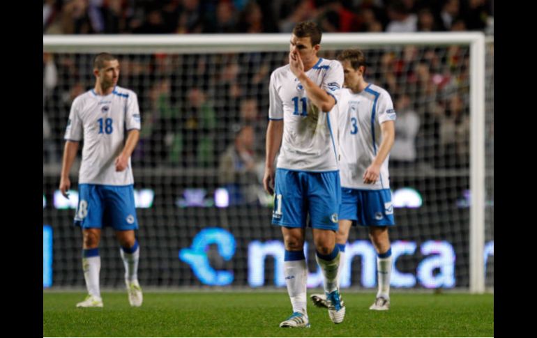 Los jugadores bosnios abandonan la cancha junto con sus esperanza de clasificar en esta repesca. AP  /