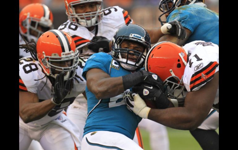 Montell Owens es detenido  por el tacleador de Cleveland Ahtyba Rubin (D)  y Usama Young (28) durante el partido. AP  /