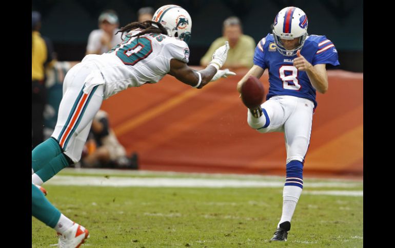 El jugador de Miami, Chris Clemons (30) bloquea a Brian Moorman (8) durante la segunda mitad del partido en Florida. AP  /