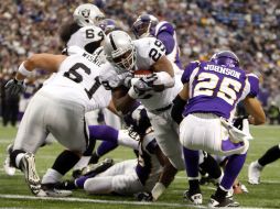 El corredor de los Raiders Michael Bush (29) atrapa un pase de touchdown ante el jugador de Vikingos Tyrell Johnson (25). REUTERS  /