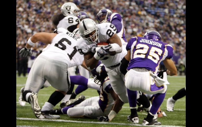 El corredor de los Raiders Michael Bush (29) atrapa un pase de touchdown ante el jugador de Vikingos Tyrell Johnson (25). REUTERS  /