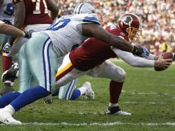 El mariscal de campo de Washingto, Rex Grossman marca un touchdown antes de ser tacleado por Jay Rattlif de Dallas. AP  /