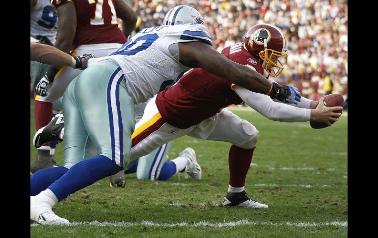 El mariscal de campo de Washingto, Rex Grossman marca un touchdown antes de ser tacleado por Jay Rattlif de Dallas. AP  /