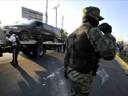 Las camionetas halladas fueron removidas del sitio sin sacar los cadáveres de su interior. AP  /