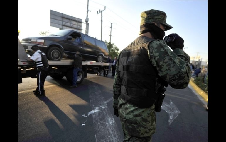 Las camionetas halladas fueron removidas del sitio sin sacar los cadáveres de su interior. AP  /