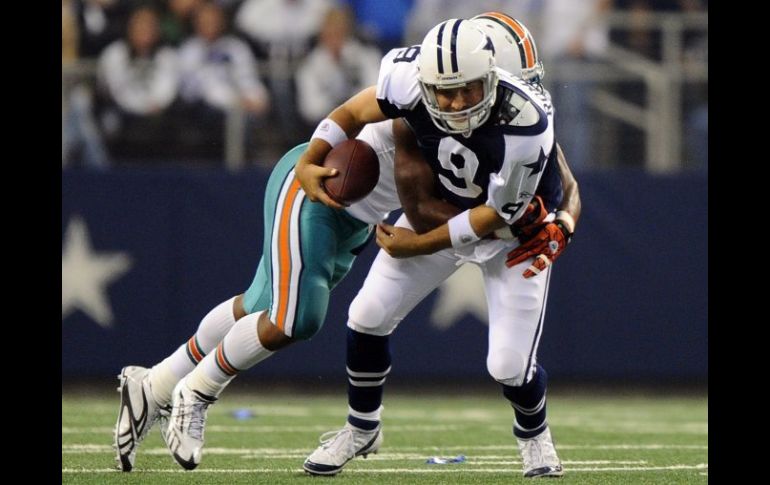 El mariscal Tony Romo (d) es derribado por Cameron Wake (i) durante la primera mitad del partido. EFE  /