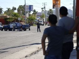 Jóvenes miran el sitio donde fue asesinado el activista sonorense mientras conducía su vehículo. REUTERS  /