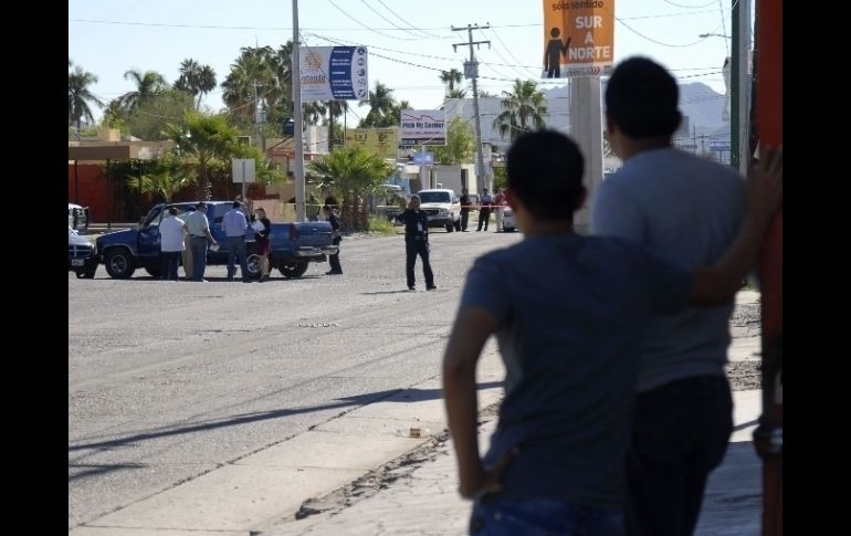 Jóvenes miran el sitio donde fue asesinado el activista sonorense mientras conducía su vehículo. REUTERS  /