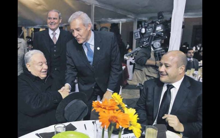 El secretario de Gobierno, Fernando Guzmán, saluda al cardenal durante la cena; los acompaña el alcalde de Tlajomulco, Enrique Alfaro.  /