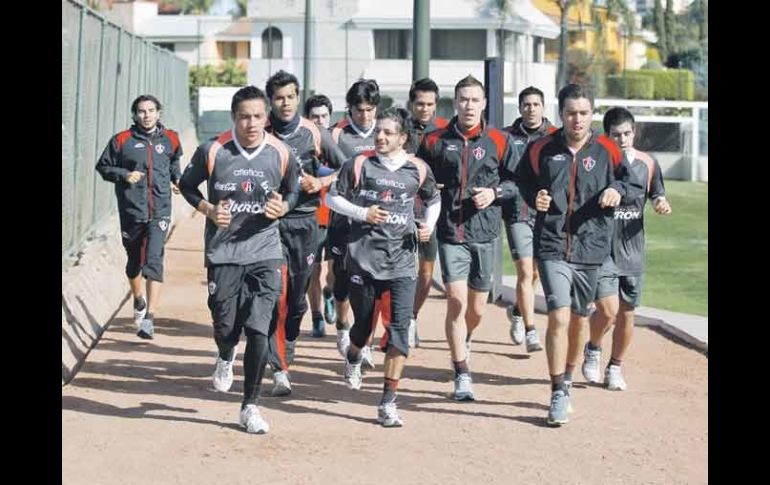 Jugadores rojinegros trotan durante al entrenamiento que realizaron ayer.  /