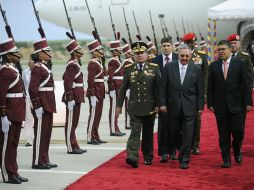 El presidente Raúl Castro (C) es recibido en el aeropuerto de Caracas.  AFP  /