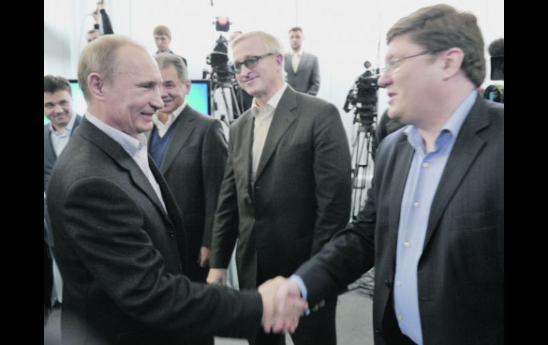 Vladimir Putin saluda a un simpatizante durante la jornada electoral. AFP  /