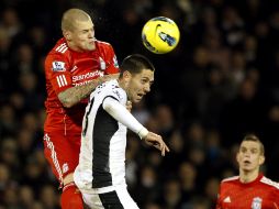 El jugador del Fulham Clint Dempsey (C) disputa el balón ante Martin Skrtel (I) del Liverpool durante el partido de la Liga Premier.EFE  /