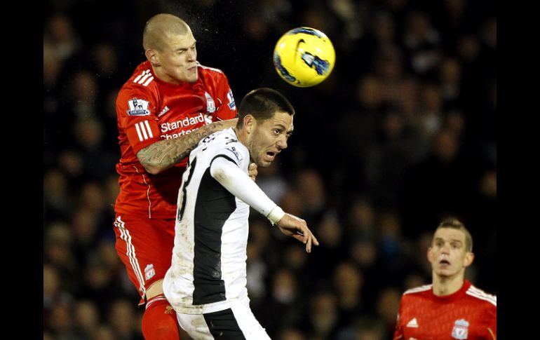 El jugador del Fulham Clint Dempsey (C) disputa el balón ante Martin Skrtel (I) del Liverpool durante el partido de la Liga Premier.EFE  /