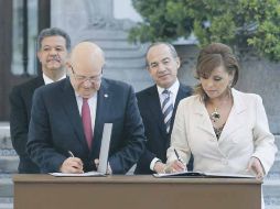 Los presidentes Leonel Fernández y Felipe Calderón (atrás) observan la firma del acuerdo. NTX  /