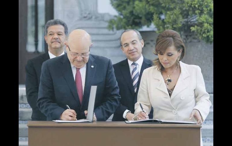 Los presidentes Leonel Fernández y Felipe Calderón (atrás) observan la firma del acuerdo. NTX  /