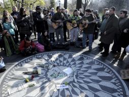 Un grupo de personas toca canciones de John Lennon junto al monumento en Central Park, en Nueva York. EFE  /