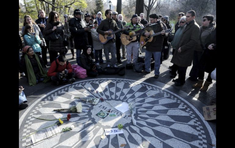 Un grupo de personas toca canciones de John Lennon junto al monumento en Central Park, en Nueva York. EFE  /