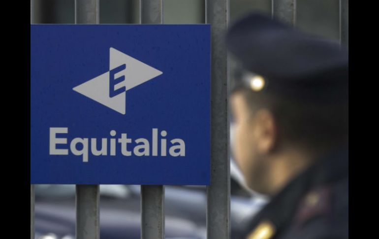 Un oficial de policía vigila en la sede de una filial de la empresa pública italiana Equitalia. EFE  /