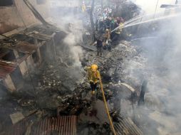 Bomberos extinguen las llamas en el lugar donde se ha estrellado una avioneta. EFE  /