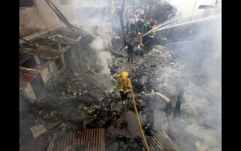 Bomberos extinguen las llamas en el lugar donde se ha estrellado una avioneta. EFE  /